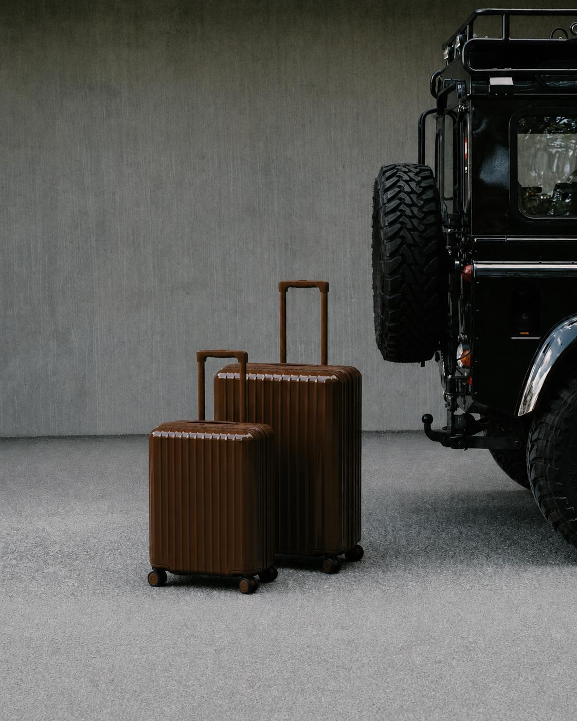 Luxury brown suitcases next to a premium vehicle